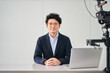 © Hiroba Studio - 撮影スタジオでニュースの配信をする30代のフリーのアナウンサーの男性