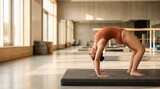 Body positive woman practicing yoga wheel pose in a sunlit modern studio
