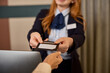 © Rido - Close up hands of receptionist giving card key to hotel guest