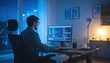 © geograph - Young man wearing glasses coding on a computer in a modern home office at night blue light