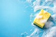 © pngking - Cleaning concept banner with a sponge and soap foam on blue background from top perspective including copy space