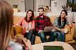 © deagreez - Friends and coworkers having a casual meeting on a couch with coffee and a laptop in a modern office lounge