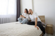© millaf (Nemchinova) - Perfect woman holding smartphone and sitting with man in modern apartment, watching video and relaxing. Couple having fun. Togetherness, happiness and entertainment concept.