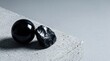 © Chanchan - Black glossy stone eggs on concrete.