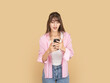 © Designerant - Surprised young woman using smartphone with open mouth expression, reacting to unexpected message. Isolated on beige background copy space, ideal for communication, news and digital reaction concepts.
