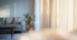 © Vhagar - A softly lit living room interior featuring a blurred view of curtains, a cozy sofa, and a plant, creating a serene and inviting atmosphere.