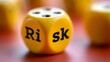 © Nick Freund - Ein gelber Würfel mit der Aufschrift „Risk' liegt auf einer roten Oberfläche, im Hintergrund weitere unscharfe Würfel
