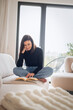 © gzorgz - Confident middle-aged woman reading a book and relaxing in her modern interior living-room