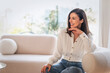 © gzorgz - Portrait of an elegant woman relaxing in an armchair in her bright, minimalist home