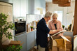 © Marko Geber - Senior couple unpacking moving boxes in kitchen
