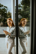 © BGStock72 - Woman enjoying a moment of reflection while using her smartphone indoors