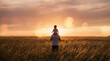 © pradeep - A silhouette of a father carrying his child on his shoulders while standing in a vast wheat field during a golden sunset.