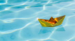 © LiaSyafitri - Golden Paper Origami Boat Floating on Crystal Clear Blue Rippled Water, Symbolizing Success and Wealth Concept