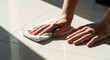 © Rodeo - Close up of hands wiping clean tiled floor with a white cloth