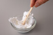 © Elena - Dipping white crochet snowflake into glue mixture for starching. Ideal for DIY craft blogs, handmade ornament tutorial publishers, hobby schools, and holiday home decor marketing campaigns