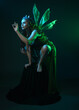 © faestock - portrait of female model wearing fantasy fairy costume, green dress, cloak, butterfly wings and crown. full length crouching  pose, isolated on dark studio background.