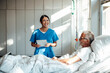 © Westend61 - Nurse providing care and support to a patient in a hospital room
