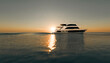 © Westend61 - Luxury yacht on a calm sea at sunset with sun reflection