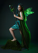 © faestock - Full length portrait of female model wearing fantasy fairy costume, green dress, cloak, butterfly wings and crown. Full length walking pose holding druid staff.  isolated on dark studio background.