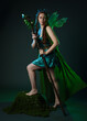 © faestock - Full length portrait of female model wearing fantasy fairy costume, green dress, cloak, butterfly wings and crown. Full length walking pose holding druid staff.  isolated on dark studio background.
