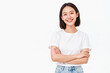 © fanjianhua - Studio portrait of a smiling young east asian woman wearing white t-shirt and jeans, crossing arms against pure white background.