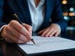 © dubogray1985 - Close-up of businessman signing contract in modern office hand holding pen above signature line