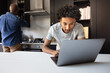 © ReeldealHD images - Teen boy using laptop for homework with father in the background