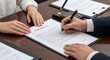 © intan - Business contract signing, close-up of hands signing document with pen at table