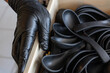 © CoreRock - Careful worker hand wearing black protective glove packing disposable plastic spoon batch inside cardboard storage box for safe catering service and sanitary food preparation industry supply