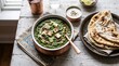 © horizon - Traditional Indian Palak Paneer dishes beautifully served in stunning hammered copper bowls featuring rich green spinach curry and cheese.