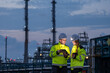 © BESTIMAGE - Two petroleum engineers team male and female hold tablet discussing and monitoring data for maintenance during night shift at oil refinery plant engineering teamwork industrial energy operation.