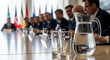 © val_webart - Business meeting with leaders discussing at a long conference table
