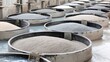 © Chee - Large industrial tanks filled with fibrous raw material undergoing processing and soaking in liquid