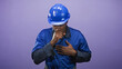 © Krakenimages.com - Man in blue hardhat and blue coveralls coughing into fist while holding chest and showing discomfort in studio; concern.