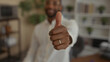 © Krakenimages.com - Man displaying thumbs up and thumbs down hand gesture with wedding ring in building; ambivalence decision.