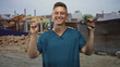 © Krakenimages.com - Man physiotherapist in blue scrubs holds handgrip, points index finger amid building construction site; confidence rehab guidance.