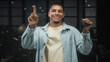© Krakenimages.com - Man holding car keys and pointing finger in studio, smiling and showing the key fob while wearing a denim jacket and t shirt; confidence celebration new car.