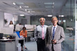 © .shock - Middle Eastern business leaders in a modern open-plan office posing confidently during a corporate meeting