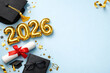 © oliamogdaleva - Graduation 2026 composition with numbers, scroll and student accessories on blue surface.
