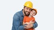 © Vasiliy - Father and son wearing construction hard hats and hugging. Man in denim shirt and boy in orange t-shirt. Safety and career inspiration concept