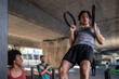 © ADDICTIVE STOCK - Athlete doing ring pull up at urban outdoor gym workout