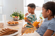 © ADDICTIVE STOCK - Hispanic family children drinking juice at breakfast table