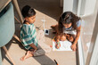 © ADDICTIVE STOCK - Hispanic children drawing renewable energy at home in sun