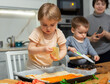 © JackF - Family are cooking italian pizza together in cozy home kitchen. Cute kids with happy mother are preparing food or meal for dinner