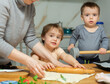 © JackF - Family are cooking italian pizza together in cozy home kitchen. Cute kids with happy mother are preparing food or meal for dinner