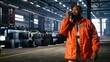 © DC Studio - Black operator talks through walkie talkie and monitoring metal fabrication equipment in workshop, handling professional responsibility and engineering tasks involved in plant operation.