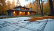 © Pete - House blueprint with pencil on paper near modern home in autumn forest. Architect plans new building. Design construction process. Real estate development.