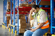 © offsuperphoto - Worker feeling exhausted and overwhelmed, leaning on a storage rack in a warehouse