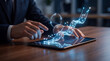 © DANG QUANG - Businessman analyzing digital financial data and growth trends on a futuristic glowing graph projected from a tablet.