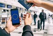 © Patrick - Traveler holding smartphone with European Union flag and American passport at airport terminal, international travel and digital visa concept for immigration and tourism